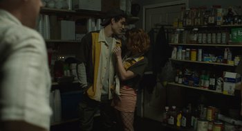Movie still from “The Passenger” (2023), directed by Carter Smith – A man and a woman standing next to each other in a room; Medium shot, Low angle