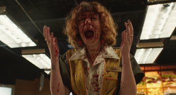 Movie still from “The Passenger” (2023), directed by Carter Smith – A woman with blood all over her face and hands; Medium shot, Low angle