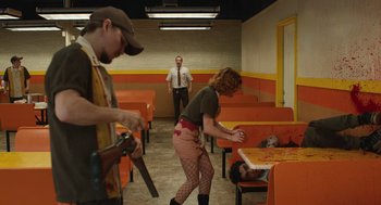 Movie still from “The Passenger” (2023), directed by Carter Smith – A man and a woman in fishnet stockings and a man in a tie; Wide shot, High angle
