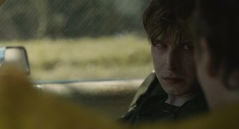 Movie still from “The Passenger” (2023), directed by Carter Smith – A man sitting in the back seat of a car; Close Up shot, Over the shoulder angle