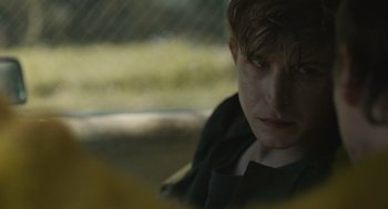 Movie still from “The Passenger” (2023), directed by Carter Smith – A man sitting in a car looking out the window; Close Up shot, Over the shoulder angle