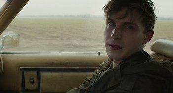 Movie still from “The Passenger” (2023), directed by Carter Smith – A man sitting in a vehicle looking out the window; Close Up shot, Over the shoulder angle