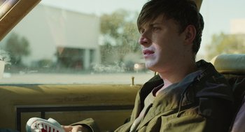 Movie still from “The Passenger” (2023), directed by Carter Smith – A man sitting in the back seat of a car looking out the window; Close Up shot, Low angle