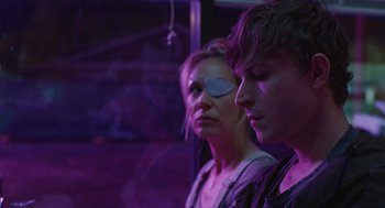 Movie still from “The Passenger” (2023), directed by Carter Smith – A woman and a man standing next to each other; Close Up shot, Over the shoulder angle