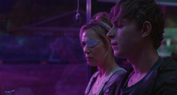 Movie still from “The Passenger” (2023), directed by Carter Smith – A woman and a man in a purple room; Close Up shot, Over the shoulder angle
