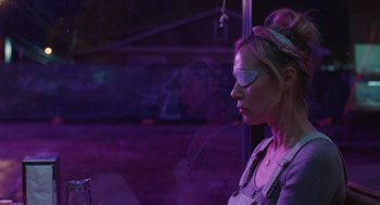 Movie still from “The Passenger” (2023), directed by Carter Smith – A woman wearing glasses looking out of a window; Close Up shot, Over the shoulder angle