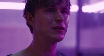 Movie still from “The Passenger” (2023), directed by Carter Smith – A young man is looking into the distance; Close Up shot, Over the shoulder angle