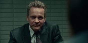 Movie still from “Dopesick” (2021), directed by Danny Strong – A person wearing a suit and tie; Close Up shot, Over the shoulder angle