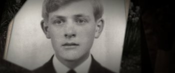 Movie still from “The Pigeon Tunnel” (2023), directed by Errol Morris – An old black and white photo of a man in a suit; Extreme Close Up shot, High angle