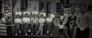 Movie still from “The Pigeon Tunnel” (2023), directed by Errol Morris – An old photo of a group of boys sitting in front of a building; Wide shot, High angle