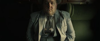 Movie still from “The Pigeon Tunnel” (2023), directed by Errol Morris – A man wearing a suit and a tie; Close Up shot, Low angle