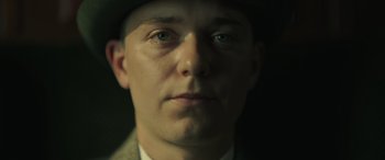 Movie still from “The Pigeon Tunnel” (2023), directed by Errol Morris – A person wearing a hat; Close Up shot, Low angle