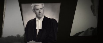 Movie still from “The Pigeon Tunnel” (2023), directed by Errol Morris – An old black and white photo of a man in a judge's outfit; Extreme Close Up shot, High angle