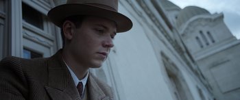 Movie still from “The Pigeon Tunnel” (2023), directed by Errol Morris – A man wearing a hat and a suit and tie; Close Up shot, Low angle