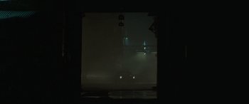 Movie still from “The Pigeon Tunnel” (2023), directed by Errol Morris – A car is driving on a street in the fog; Extreme Wide shot, Low angle