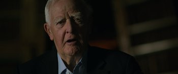 Movie still from “The Pigeon Tunnel” (2023), directed by Errol Morris – An older man in a suit is looking at the camera; Close Up shot, Low angle