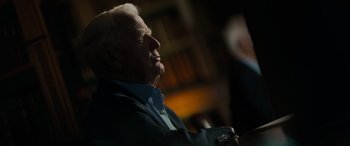 Movie still from “The Pigeon Tunnel” (2023), directed by Errol Morris – An older man in a blue shirt and a black suit; Close Up shot, Over the shoulder angle