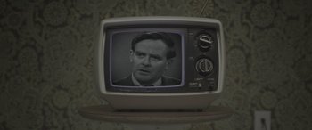 Movie still from “The Pigeon Tunnel” (2023), directed by Errol Morris – An old tv with a picture of a man on the screen; Close Up shot, High angle
