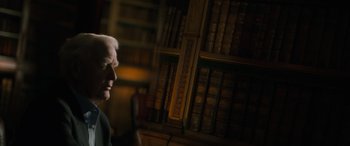 Movie still from “The Pigeon Tunnel” (2023), directed by Errol Morris – An older man in front of a book shelf; Close Up shot, Over the shoulder angle