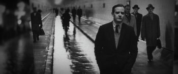 Movie still from “The Pigeon Tunnel” (2023), directed by Errol Morris – A black and white photo of a man in a suit and tie; Close Up shot, Low angle
