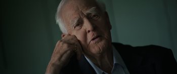 Movie still from “The Pigeon Tunnel” (2023), directed by Errol Morris – An older man is looking at the camera; Close Up shot, Low angle