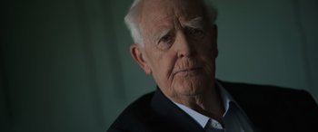 Movie still from “The Pigeon Tunnel” (2023), directed by Errol Morris – An old man with a white beard looking at the camera; Close Up shot, Low angle