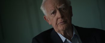Movie still from “The Pigeon Tunnel” (2023), directed by Errol Morris – An older man wearing a suit and tie; Close Up shot, Low angle