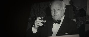 Movie still from “The Pigeon Tunnel” (2023), directed by Errol Morris – An older man in a tuxedo holding a glass of wine; Close Up shot, Low angle