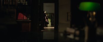 Movie still from “The Pigeon Tunnel” (2023), directed by Errol Morris – Two people are standing in a dark room; Wide shot, High angle