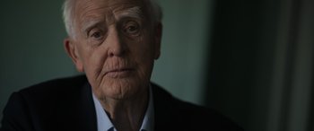 Movie still from “The Pigeon Tunnel” (2023), directed by Errol Morris – An old man with a white beard is looking at the camera; Close Up shot, Over the shoulder angle