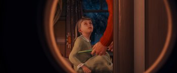 Movie still from “The Polar Express” (2004), directed by Robert Zemeckis – A woman holding a pencil in front of a child; Medium shot, High angle