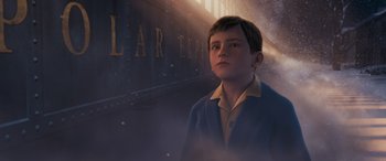 Movie still from “The Polar Express” (2004), directed by Robert Zemeckis – A young boy standing in front of a train car; Medium shot, Low angle