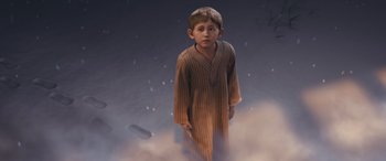 Movie still from “The Polar Express” (2004), directed by Robert Zemeckis – A young boy in a nightgown standing in the snow; Medium shot, High angle