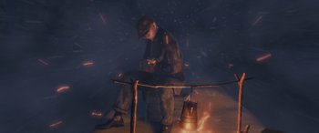 Movie still from “The Polar Express” (2004), directed by Robert Zemeckis – A man sitting in front of an open fire holding something; Medium shot, High angle