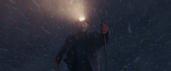 Movie still from “The Polar Express” (2004), directed by Robert Zemeckis – A man holding a pair of ski poles while wearing a hat and holding a flashlight; Medium shot, Low angle