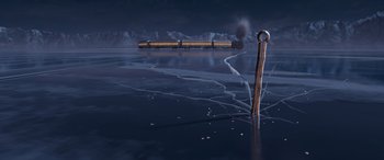 Movie still from “The Polar Express” (2004), directed by Robert Zemeckis – A train traveling on a train track near a body of water at night time; Extreme Wide shot, High angle