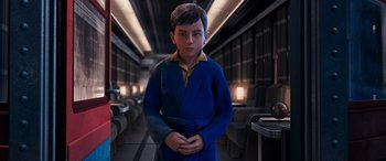 Movie still from “The Polar Express” (2004), directed by Robert Zemeckis – A boy in a blue robe standing in a train car; Medium shot, High angle