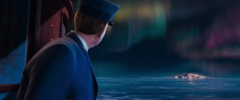 Movie still from “The Polar Express” (2004), directed by Robert Zemeckis – A man wearing a hat standing next to a body of water; Medium shot, Over the shoulder angle