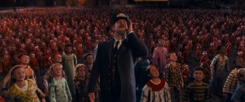 Movie still from “The Polar Express” (2004), directed by Robert Zemeckis – A crowd of people are gathered around a man in a suit; Medium shot, High angle