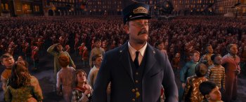 Movie still from “The Polar Express” (2004), directed by Robert Zemeckis – A man in a uniform standing in front of a crowd of people; Medium shot, High angle