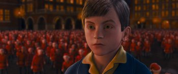 Movie still from “The Polar Express” (2004), directed by Robert Zemeckis – A young boy stares at the camera in front of a crowd of people; Close Up shot, High angle