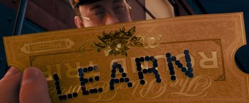 Movie still from “The Polar Express” (2004), directed by Robert Zemeckis – A man holding a sign that says " earth " on top of it; Extreme Close Up shot, Low angle