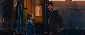 Movie still from “The Polar Express” (2004), directed by Robert Zemeckis – A man and a boy are standing next to each other in front of a train; Medium shot, Over the shoulder angle