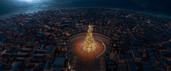 Movie still from “The Polar Express” (2004), directed by Robert Zemeckis – An aerial view of a city at night with a lit up christmas tree in the middle of it; Extreme Wide shot, High angle