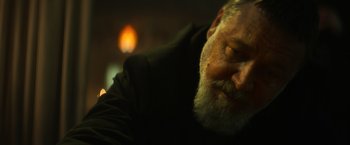 Movie still from “The Pope's Exorcist” (2023), directed by Julius Avery – A man with a long beard is looking down; Close Up shot, Low angle