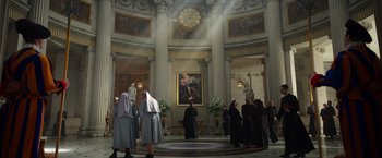 Movie still from “The Pope's Exorcist” (2023), directed by Julius Avery – A group of people standing in front of a large clock; Extreme Wide shot, Low angle