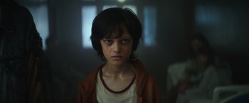 Movie still from “The Pope's Exorcist” (2023), directed by Julius Avery – A young girl with a bruised face stares into the camera; Close Up shot, Low angle