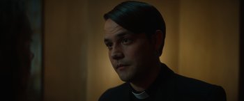 Movie still from “The Pope's Exorcist” (2023), directed by Julius Avery – A man in a priest's outfit looking into the distance; Close Up shot, Low angle