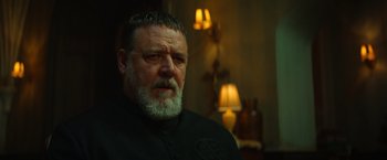 Movie still from “The Pope's Exorcist” (2023), directed by Julius Avery – A man with a gray beard is looking at the camera; Close Up shot, Low angle