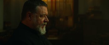 Movie still from “The Pope's Exorcist” (2023), directed by Julius Avery – An older man with a beard looking to his left; Close Up shot, Over the shoulder angle